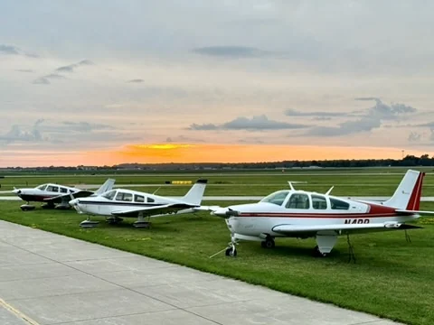 Three Flying Country Club aircraft parked together at sunset