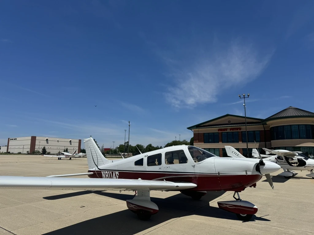 Piper Archer II N8114F parked on the ramp in front of the airport terminal, photographed from the front quarter