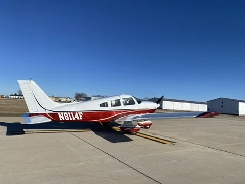 Piper Archer II N8114F parked on the ramp in the sunshine, photographed from the side