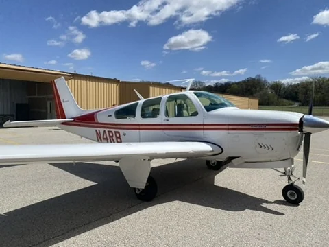 Beechcraft Bonanza N4RB parked beside a hangar on a sunny day