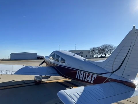 Rear-quarter view of Piper Archer II N8114F on the apron in daylight