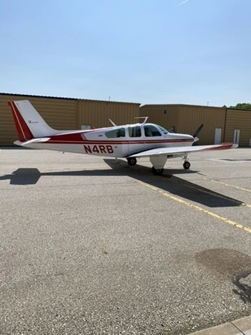 Rear-quarter profile of Beechcraft Bonanza N4RB on a sunlit apron