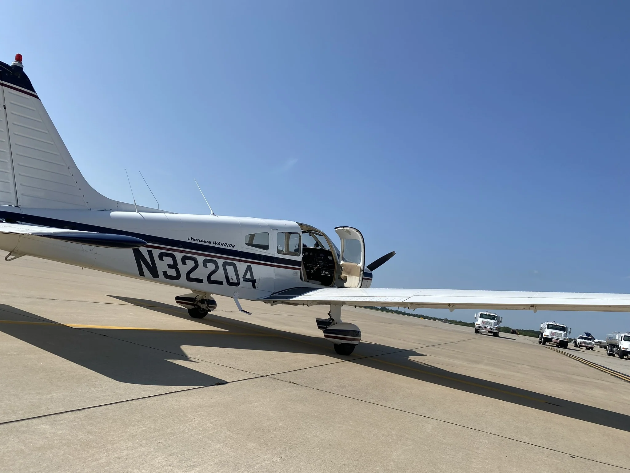 Piper Warrior N32204 parked on a sunlit airport ramp