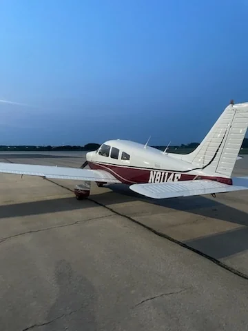 Rear-side view of a Piper Archer parked on the airport apron