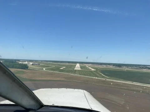 Pilot-eye cockpit view toward a runway on approach
